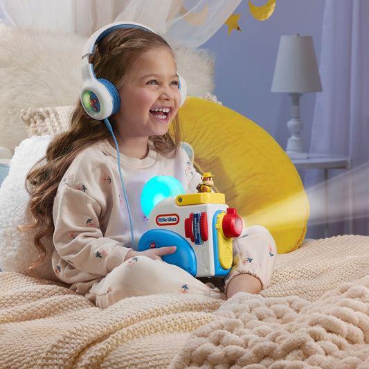 Child wearing headphones holding a Story Dream Machine in a cozy room
