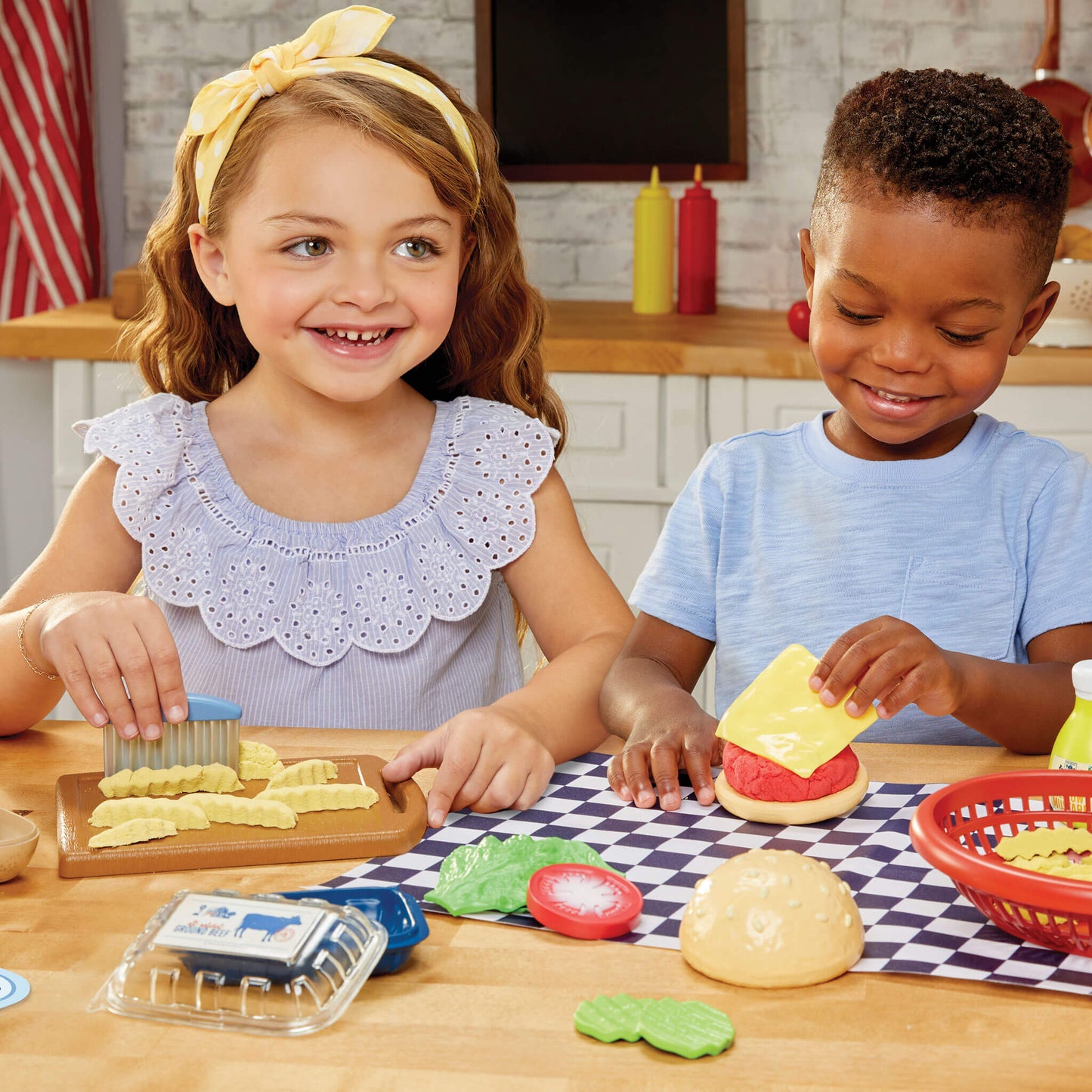 Two children making burgers and fries