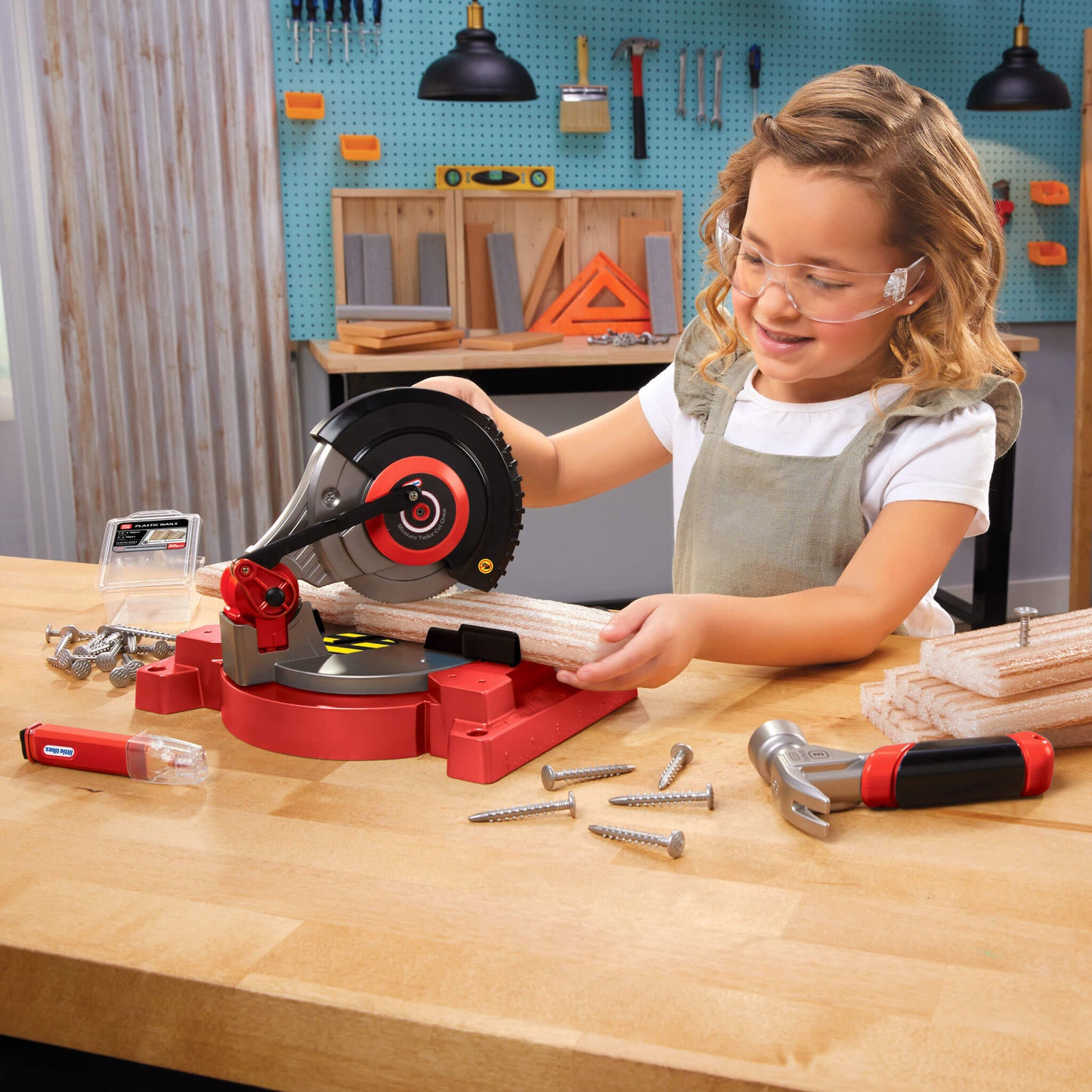 Girl using a toy saw in a workshop setting