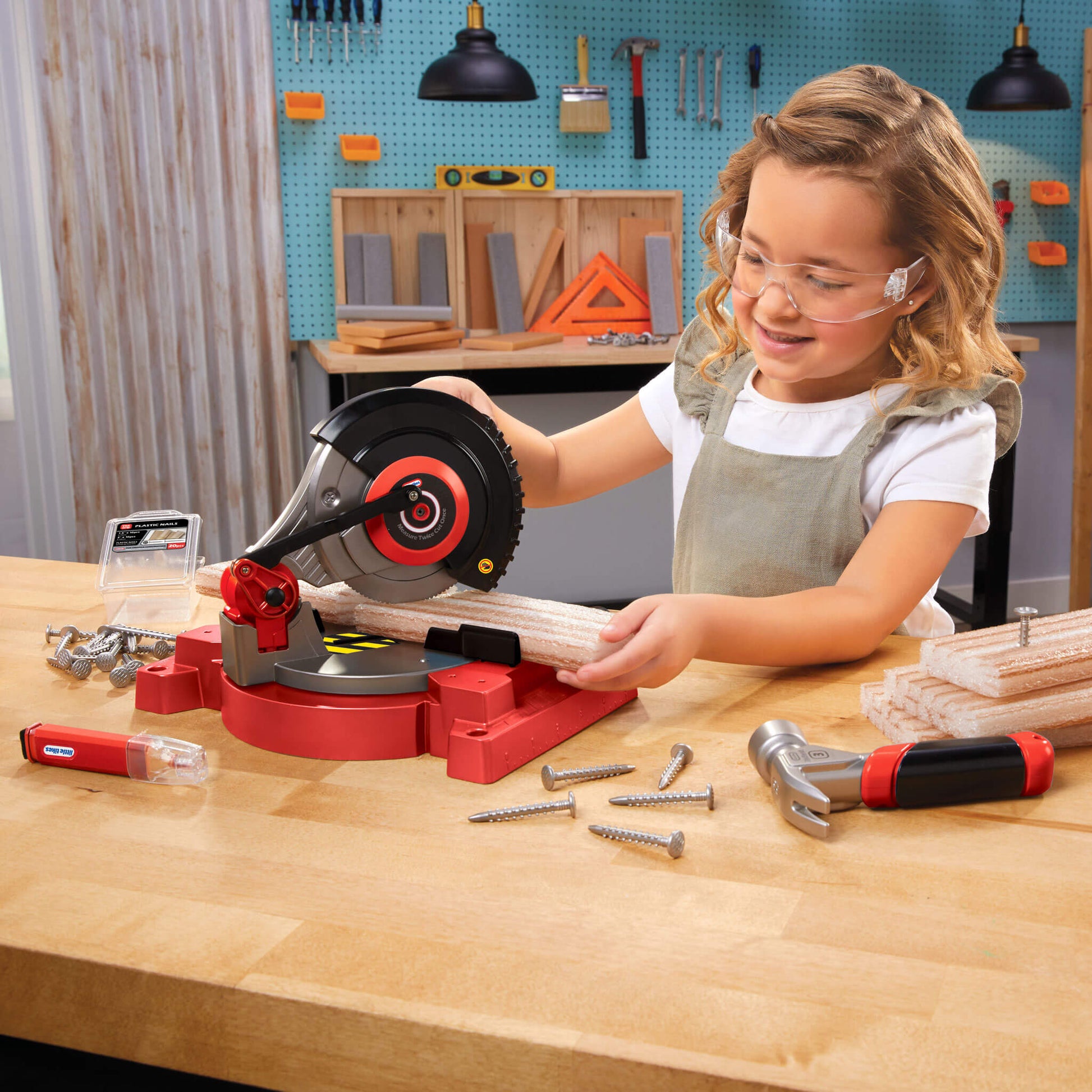 Girl using a toy saw in a workshop setting