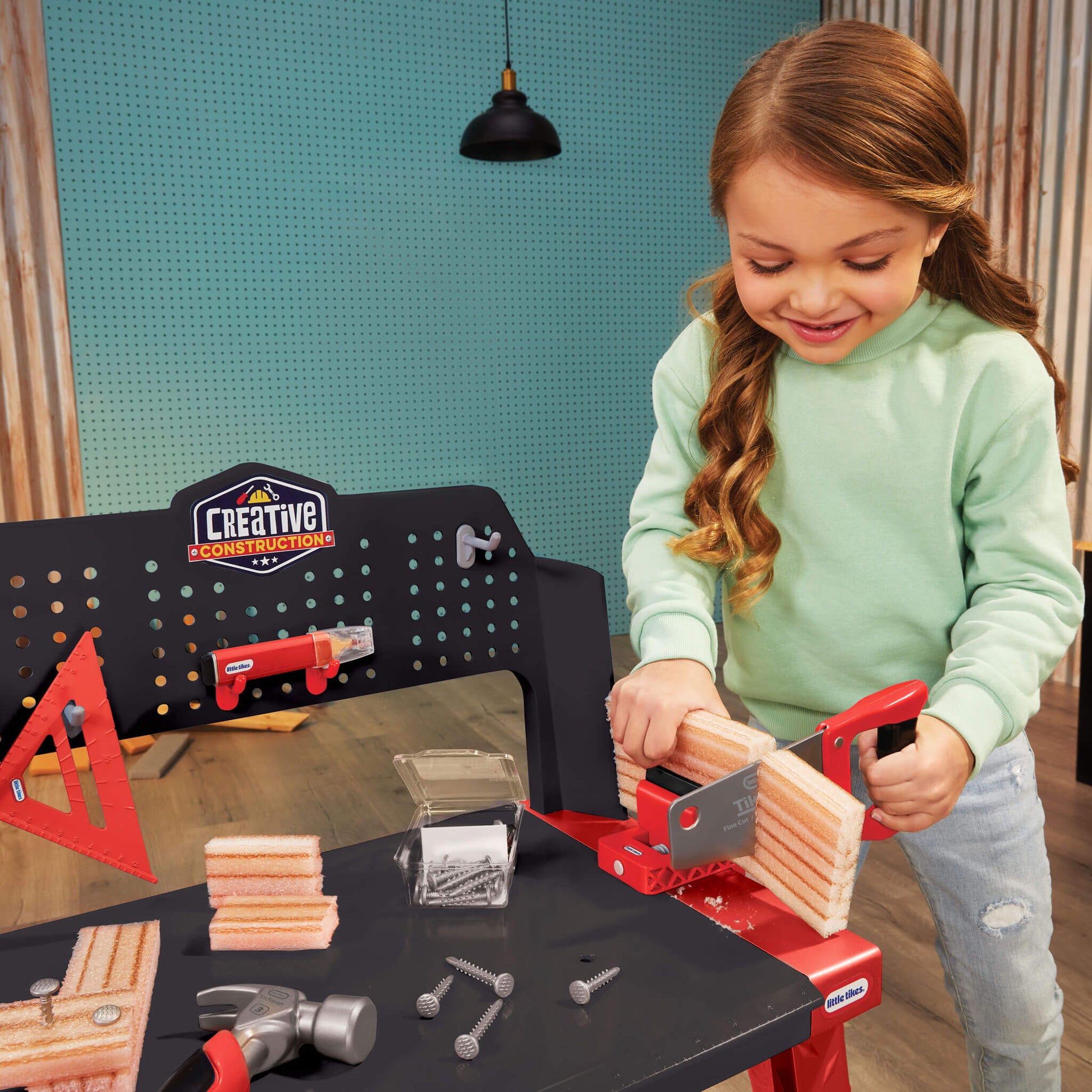 Girl playing with a toy workbench and tools