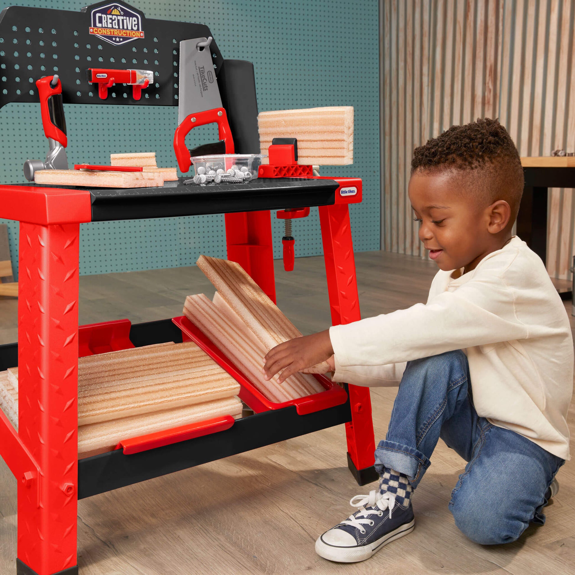 Boy stacking foam wood under workbench