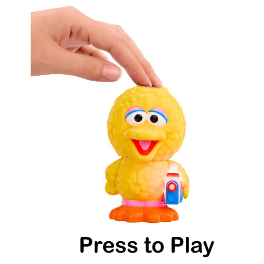 Yellow toy figure with a hand pressing a button labeled 'Press to Play' on a white background