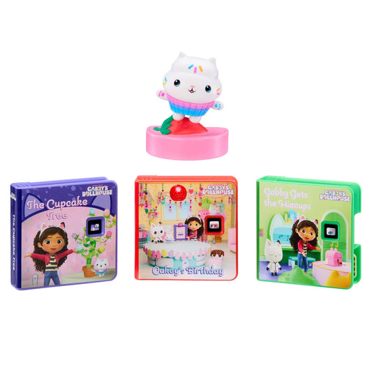 A set of Gabby's Dollhouse toy books and a small white cat figurine on a pink base, shown on a plain white background.