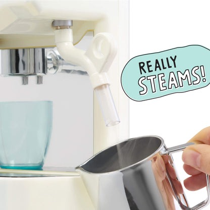 A close-up of a white espresso machine dispensing steam into a pitcher held by a hand. A light blue speech-bubble graphic reads 'REALLY STEAMS!'.