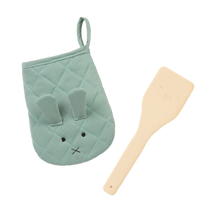 Green rabbit-shaped oven mitt and wooden spatula on a white background