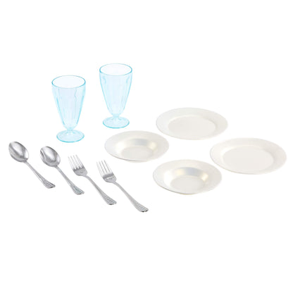 Dinnerware set with white plates, silver cutlery, and blue glasses on a white background