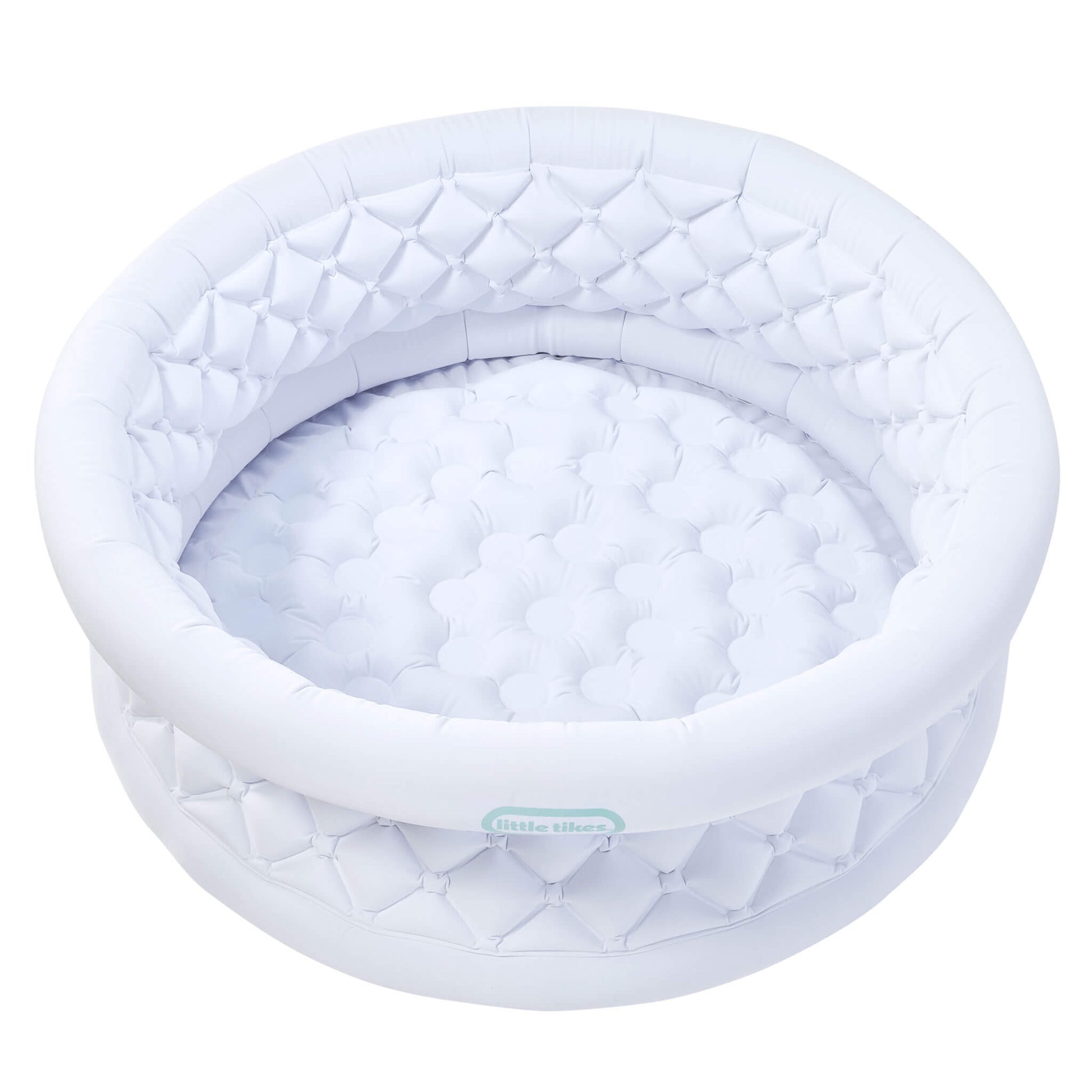 A white inflatable with a quilted diamond-patterned rim and a matching padded interior, shown on a plain white background. A small light blue-green brand label reading 'little tikes' is visible on the front edge.