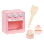 Pink oven, two cupcakes and a spatula on a white background