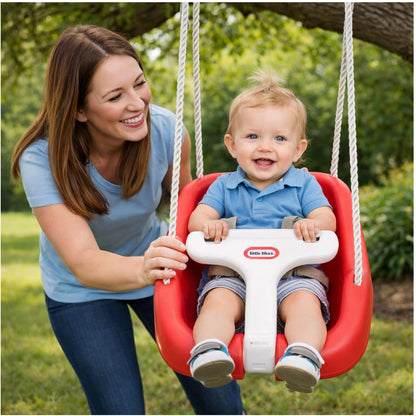 Woman pushing a child in a red and white swing set outdoors.