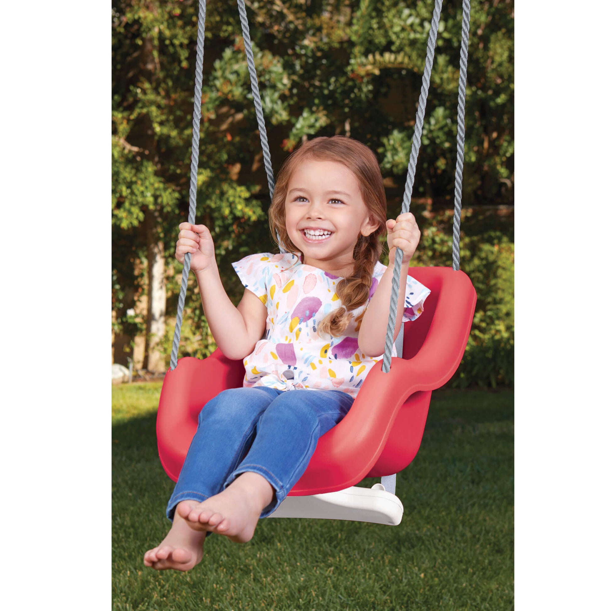 Child on a red swing set in a park